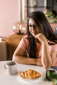 Portrait of young woman sitting on table