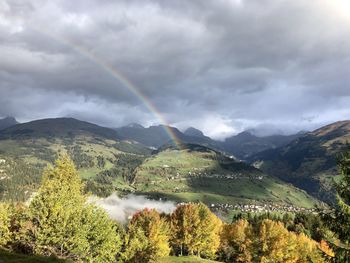 Scenic view of rainbow over mountains against sky