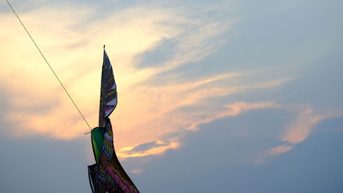 Low angle view of flags against sky during sunset