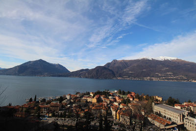 Town by lake and mountains against sky