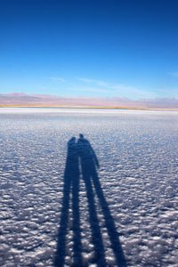 Focus on shadow of couples on salt lake