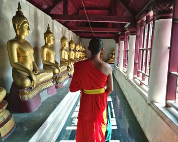 Rear view of buddhist monk standing at temple