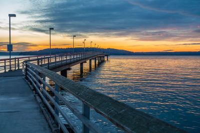 Bridge over sea against sky during sunset