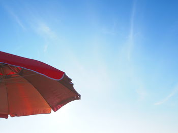 Low angle view of red flags hanging against sky