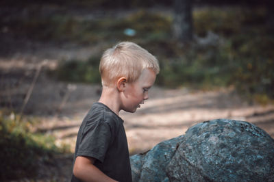 Boy looking away on rock