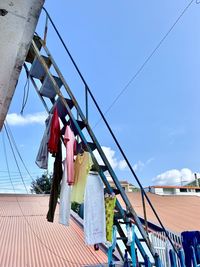 Low angle view of clothes drying on rope against sky