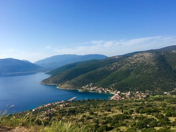 Scenic view of sea and mountains against sky