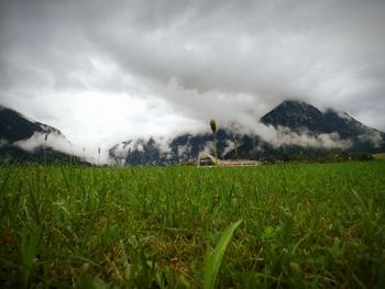 Scenic view of field against cloudy sky