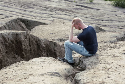 Side view of woman sitting on rock