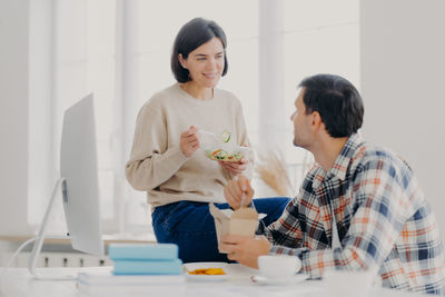 Couple working on desktop pc at home