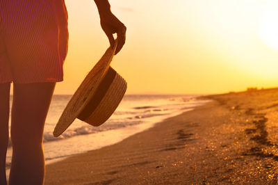 Low section of man standing on beach