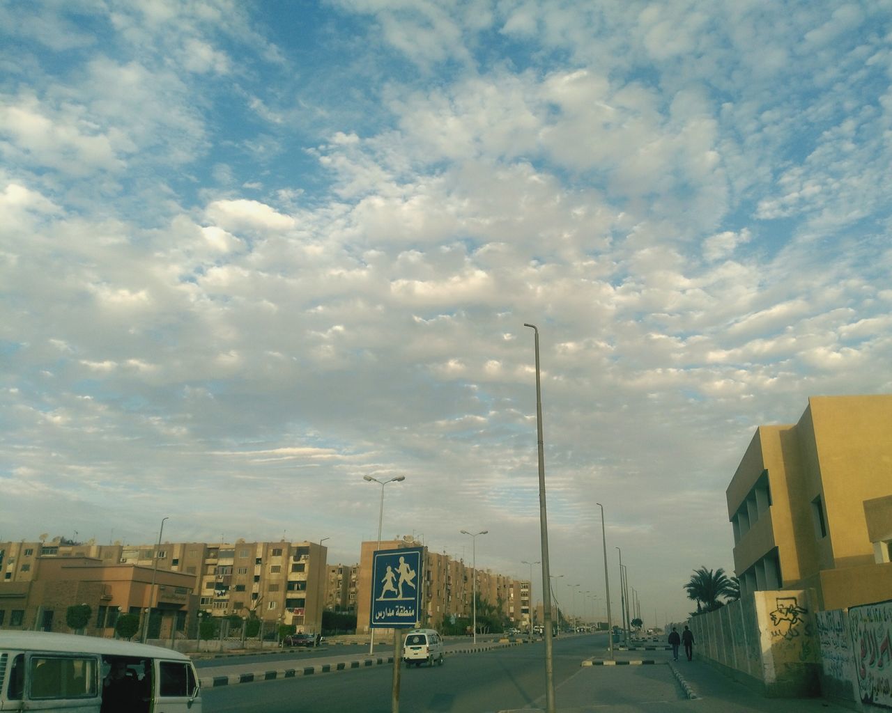 CARS ON ROAD AGAINST SKY IN CITY