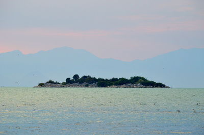 Scenic view of sea and mountains against sky