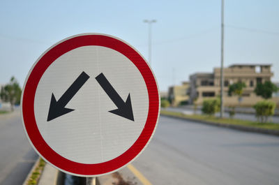 Close-up of road sign against sky 