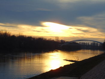 Bridge over river at sunset