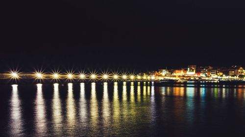 Illuminated buildings against sky at night