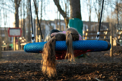 2 girls swinging on a swing