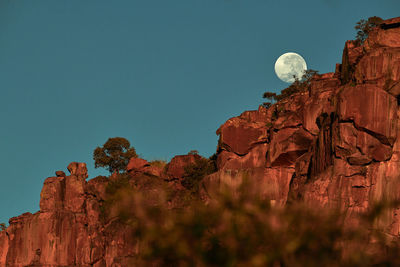 Low angle view of rock formation against clear blue sky