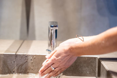 Close-up of person hand holding faucet