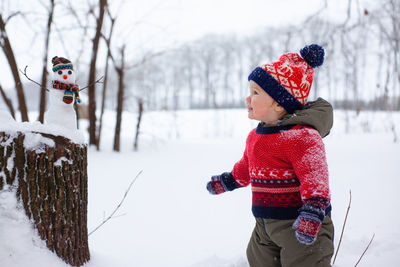 Low angle view of boy standing on snow