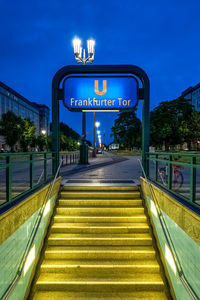 Information sign on road in city against sky