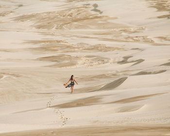 Rear view of man walking on sand at beach