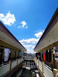 People on street amidst buildings in city against sky