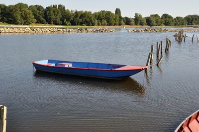 Boat moored in lake against trees