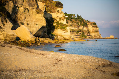 Rock formations by sea against sky