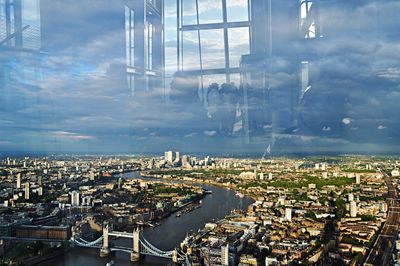 Aerial view of cityscape against cloudy sky