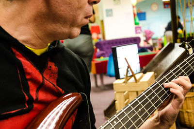 Midsection of man playing guitar