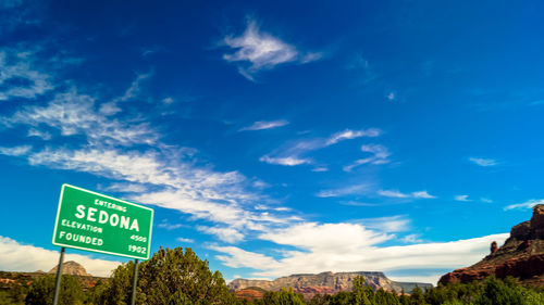 Road sign against blue sky