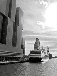 Modern buildings by sea against sky in city