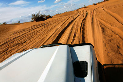 Cropped image of vehicle moving on desert