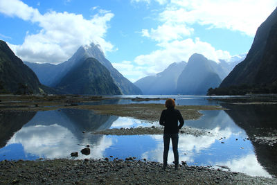 Rear view of woman standing by lake