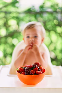 Portrait of boy eating fruits in bowl