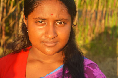 Close-up portrait of smiling girl at farm outdoors