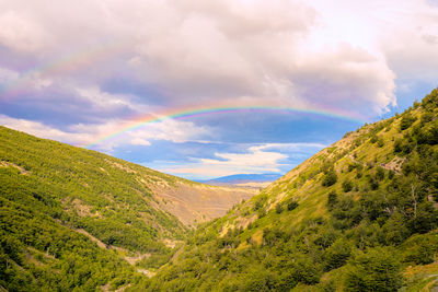 Scenic view of rainbow over mountains against sky