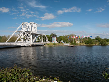 Bridge over river against sky in city