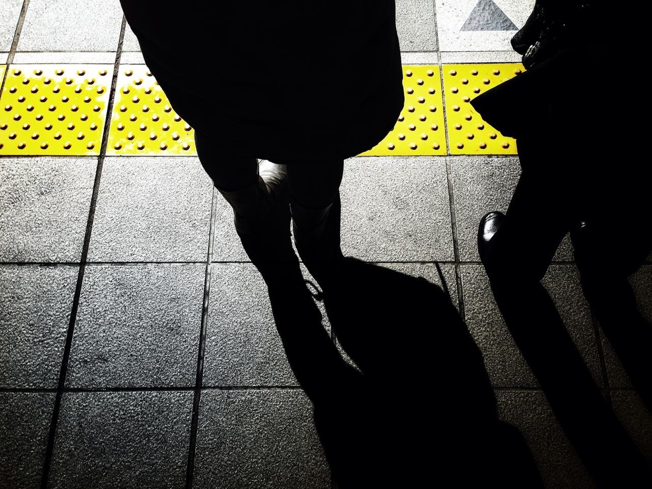 low section, person, standing, lifestyles, men, walking, indoors, leisure activity, yellow, shoe, human foot, tiled floor, shadow, rear view, casual clothing