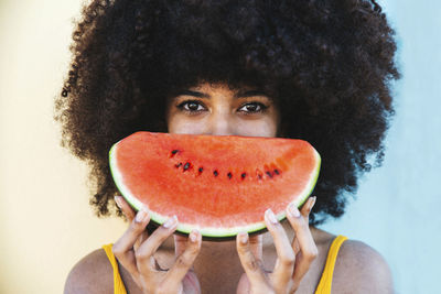 Young afro woman holding slice of watermelon