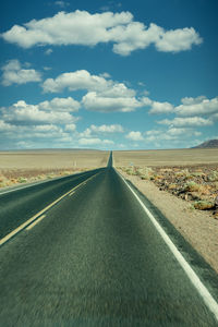 Empty road along countryside landscape