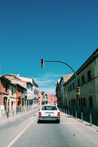 Vehicles on road against clear blue sky