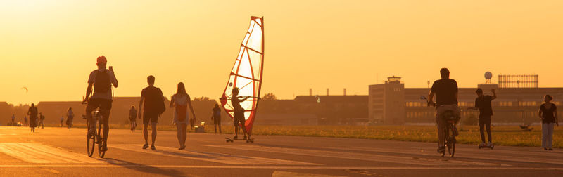 People at observation point against sky during sunset