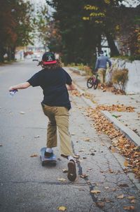 Rear view of woman standing on road