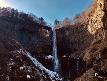 Scenic view of waterfall against sky