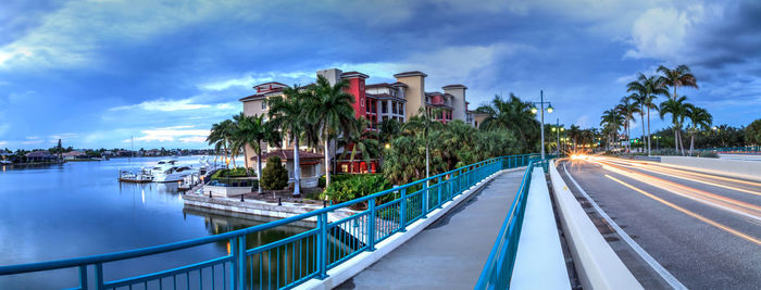 Panoramic shot of palm trees by city against sky