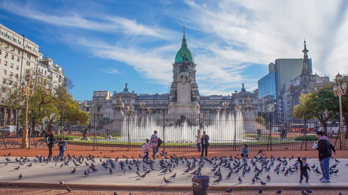 Group of people in front of buildings against sky