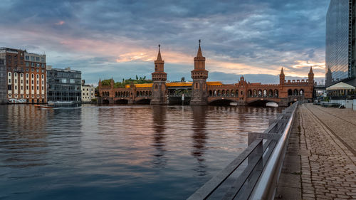 View of oberhausen bridge at waterfront against cloudy sky