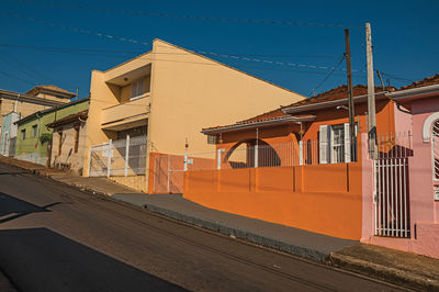 Working-class colored houses and fences in an empty street on a sunny day at são manuel, brazil.
